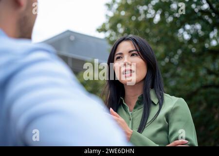 Woman talking with friend in park Stock Photo