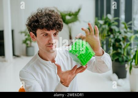 Businessman examining cube maze in office Stock Photo