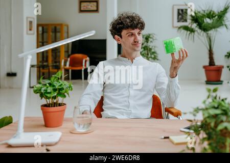 Smiling businessman examining cube maze at desk in office Stock Photo
