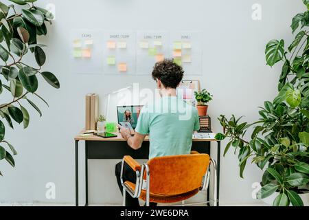 Web designer working on laptop at desk in office Stock Photo
