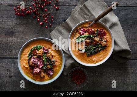 Studio shot of bowl of ready-to-eat pumpkin soup with croutons and beetroot chips Stock Photo