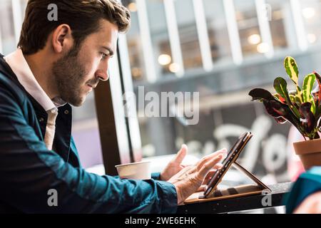Businessman using tablet PC at cafe Stock Photo
