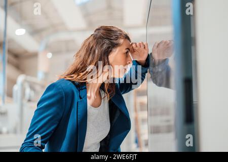 Businesswoman looking at computer screen in workshop Stock Photo