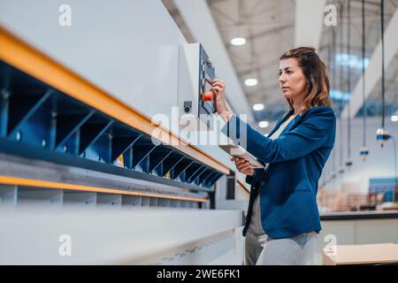 Engineer with tablet PC using control panel in industry Stock Photo