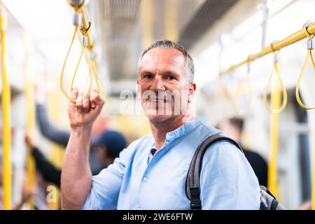Smiling businessman commuting by train Stock Photo