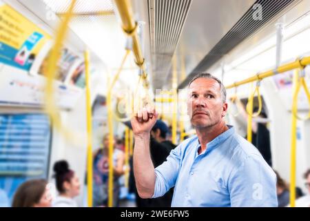 Businessman holding handgrip and commuting through train Stock Photo