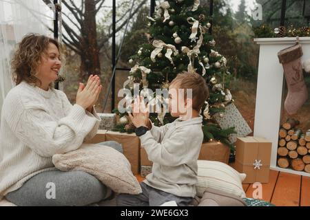 Smiling mother and son playing clapping game at home Stock Photo