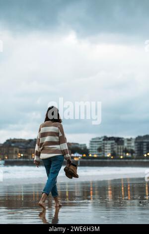 Young woman walking on Playa de la Concha shore Stock Photo