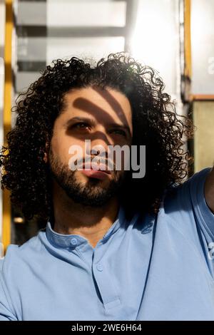 Man with curly hair wearing blue polo shirt Stock Photo