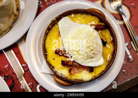 Traditional Romanian Bulz with polenta, cheese, egg and bacon at Casa Ancutei restaurant, Busteni, Romania Stock Photo