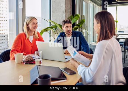 Young businessman discussing with colleagues over data in office Stock Photo