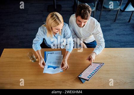 Smiling business people discussing over graph on tablet PC Stock Photo