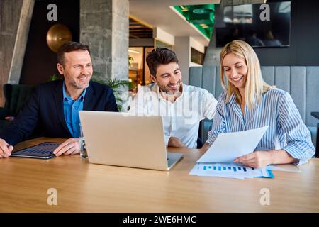 Smiling business people analyzing graphs and data at desk Stock Photo