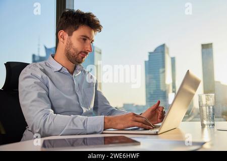 Young businessman working on laptop in office Stock Photo