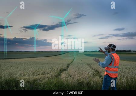 Engineer looking at digital wind turbine models in field Stock Photo