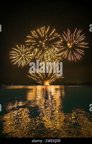 Italy, Veneto, Fireworks exploding over lake Garda at night Stock Photo