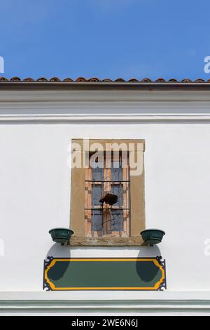 261 Barred wood window on white wall, Ottoman building in Petraq Nasi-Stavri Gjerazi streets, Old Bazaar -Pazari i Vjeter- area. Korca-Albania. Stock Photo
