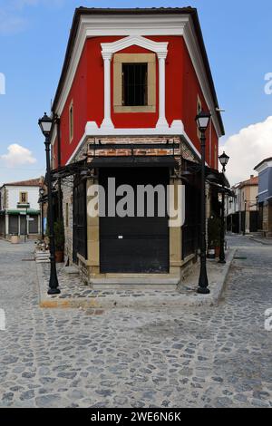 262 Crimson colored, Neoclassical-style corner house of rendered brickwork on the cobbled Rugica Petraq Nasi st., Old Bazaar area. Korca-Albania. Stock Photo