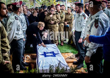 Family members weep as they touch the coffin of Major Ilay Levy during his funeral ceremony at the Tel Aviv's military cemetery. Major, Ilay Levi, 24, was killed in battle in southern Gaza Strip. Twenty-four Israeli soldiers were killed in Gaza on Monday, by far the biggest single-day Israeli death toll in the three-month war against Hamas, as talks about a ceasefire intensified and Palestinian casualties continued to climb.The deaths came amid fierce fighting around the southern city of Khan Younis, with dozens of Palestinians killed and wounded. The Israeli casualties are likely to increase Stock Photo