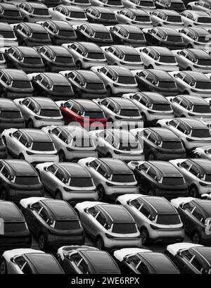 Zeebrugge Belgium Europe. 21.12.2024. A red car among new cars parked on the dockside for export and import in. the motor trade. Stock Photo