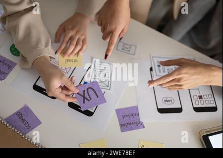 A cropped shot of a group of UX and UI graphic designers working and brainstorming on a new mobile application design in the meeting. businesspeople c Stock Photo