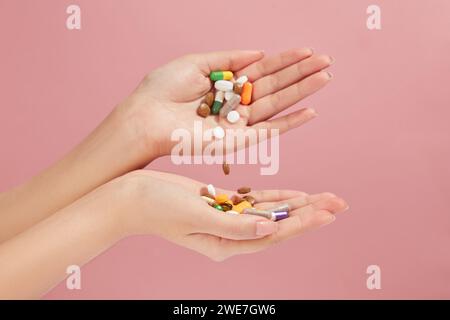 Multicolor pills, tablets and capsules are arranged on both hands with light background. Concept of medicine and health support Stock Photo
