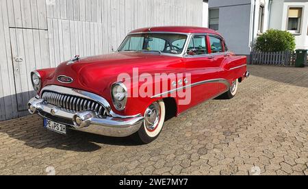 A shiny red classic car with chrome details parked in front of a white garage door, classic car, Buick Eight, Ilsede, Peine district, Lower Saxony Stock Photo