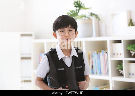 Graduation, entrance, and new semester Cute and smart student happily going to school with a bright smile on his backpack. Stock Photo