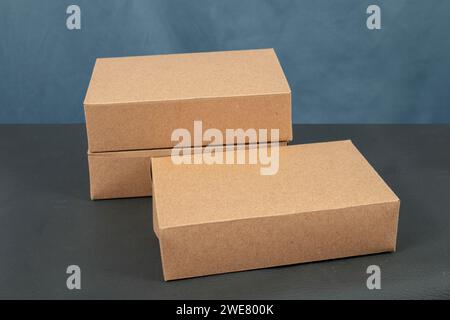 Cardboard boxes on a black table, isolated on a dark background Stock Photo