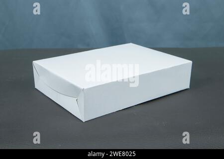 Cardboard boxes on a black table, isolated on a dark background Stock Photo