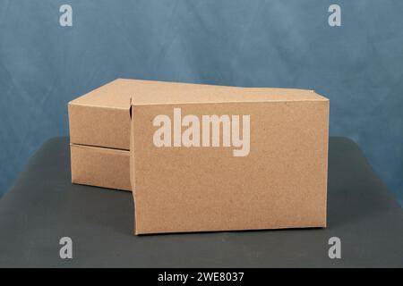 Cardboard boxes on a black table, isolated on a dark background Stock Photo