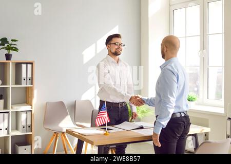 Man shaking hands with public services worker in the office of the US embassy. Stock Photo