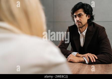 Back view of unrecognizable businesswoman having meeting with serious male colleague in office. Concept of company CEO negotiating with business Stock Photo