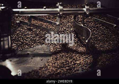 Close up of beans in a stainless steel industrial coffee roaster for an artisan coffee maker. Stock Photo