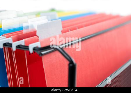 Closeup view of the colorful hanging file folder on the file organizer isolated over a white background Stock Photo