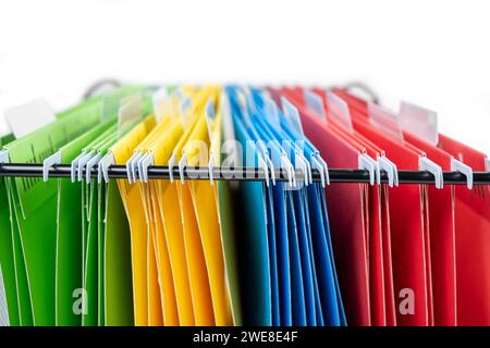 Closeup view of the colorful hanging file folder on the file organizer isolated over a white background Stock Photo