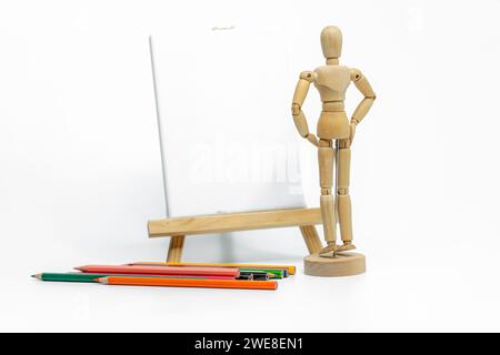 Wooden doll with empty easel on white background; business or creative concept Stock Photo