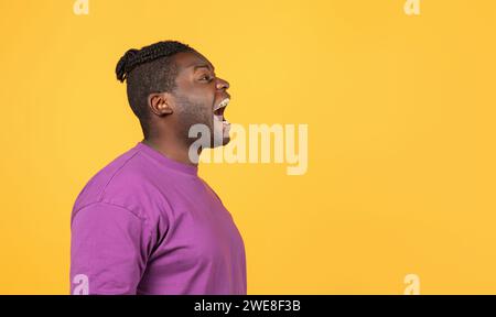 Side view of mad african american guy shouting looking aside Stock Photo