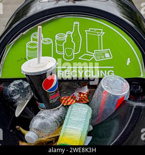 Street recycling bin overflowing with cups and plastic bottles. Stock Photo