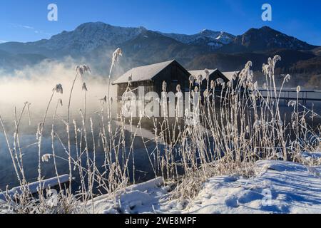 Boathouses on lake in front of mountains, winter, snow, Lake Kochelsee, Upper Bavaria, Bavaria, Germany, Europe Stock Photo