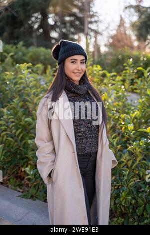 A well-dressed woman enjoys a leisurely walk among vibrant autumn leaves in the city park. Stock Photo