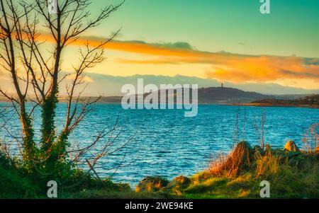 A serene evening view of Scrabo hill and tower in Newtownards, County Down, Northern Ireland, seen from across Strangford Lough at Mount Stewart. Stock Photo