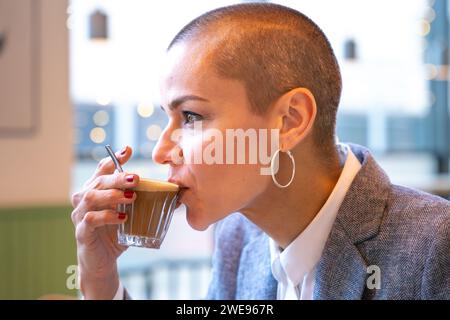 Side view stylish woman drinking coffee in cafe Stock Photo