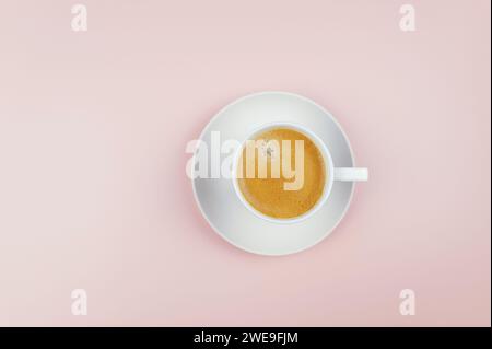 Top view of coffee cup on light pink background. White cup with plate, flat lay, copy space. Stock Photo