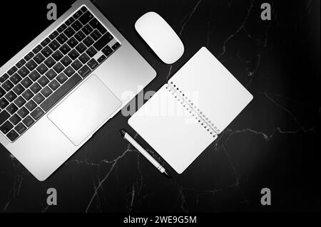 Top view of black tablet case, white pen on pink and white marble background. Modern office flat lay, copy space. Stock Photo