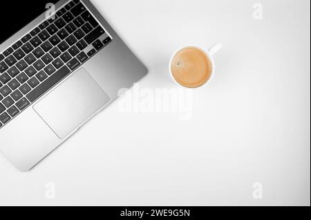 Top view of grey laptop computer on white background. Coffee cup, flat lay, copy space. Stock Photo