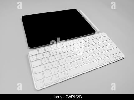 White keyboard, tablet and pen on light grey background. Modern office, copy space. Stock Photo