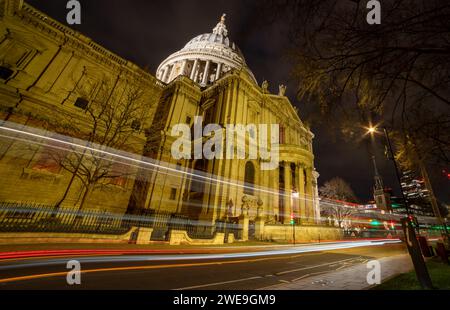 London. UK-01.20.2024. A long exposure night street view of St. Paul's Cathedral with sky scrapers in the background and vehicle light trails. Stock Photo