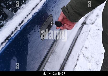 in the man's hand is the key with which he opens the car door Stock Photo