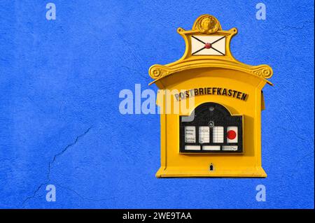 Ein alter nostalgischer Postbriefkasten hängt an einer blauen Hausfassade Stock Photo